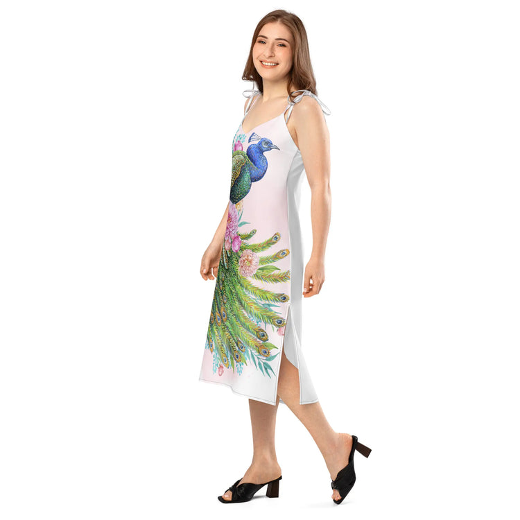 A model wearing a Baliveno peacock print midi dress with tie straps, showcasing a vibrant and chic peacock design.