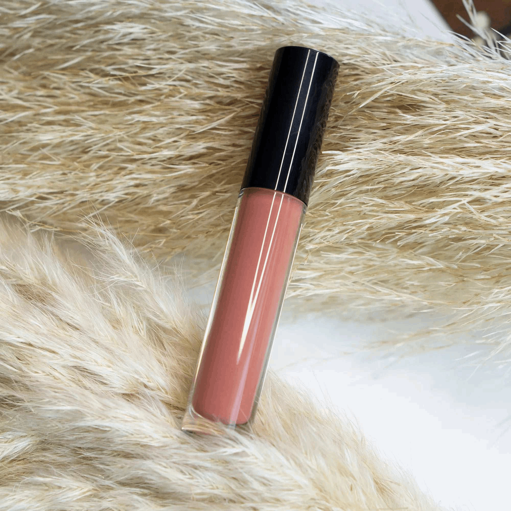 Lip Gloss - Pearl with illuminating shine on textured background.