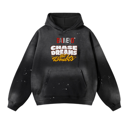 The ODMPOD Baliveno Vintage Wash Frayed Fleece Hoodie (360 GSM) features a black faded splatter design and bold red, white, and yellow BALENO®, CHASER OF ALL, CHASE DREAMS No Doubts text on the front.