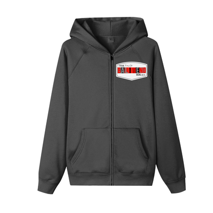 The ODMPOD Essential Zip-up Hoodie is a dark gray unisex sweatshirt with a loose fit, front pockets, and a white chest patch showing BALDINO in bold red letters with small black text. Perfect for daily casual wear.